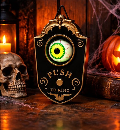 Eyeball Doorbell on a table beside a skull, a candle and a pumpkin